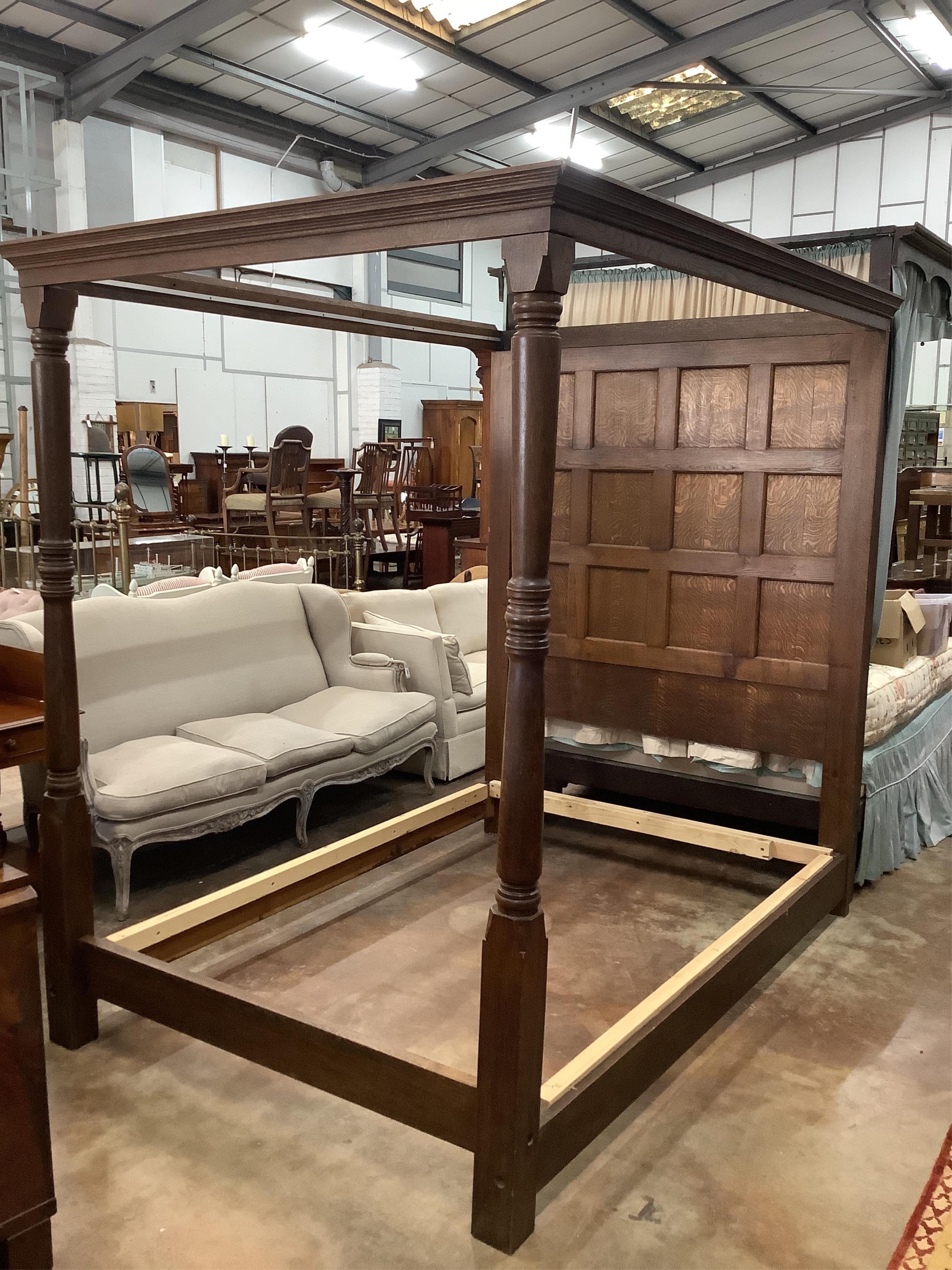 An 18th century style panelled oak four poster bed frame, width 150cm, length 215cm, height 209cm. Condition - good